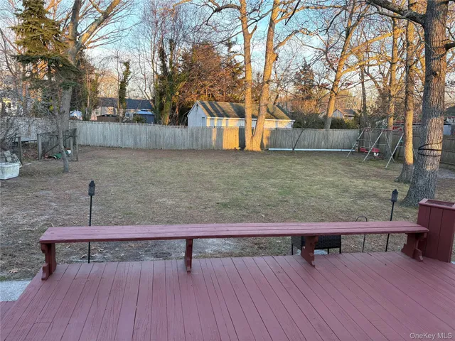 a view of a wooden deck and a backyard