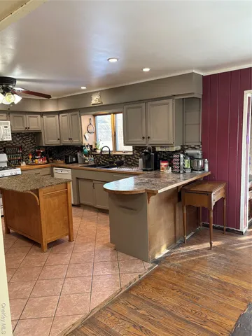 a kitchen with stainless steel appliances granite countertop a stove a sink and a microwave