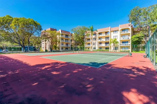 a view of a building with a big yard and palm trees