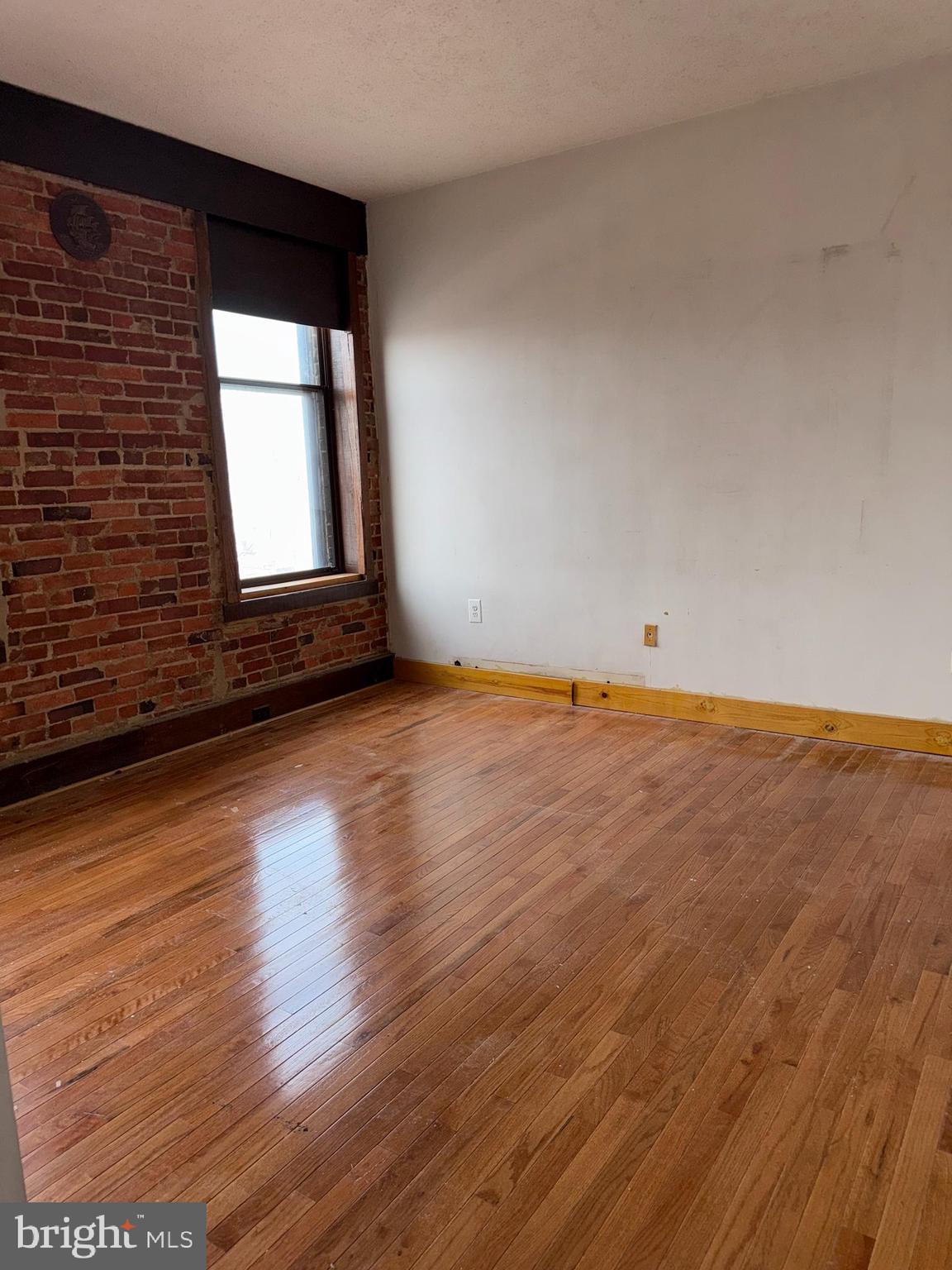 1615 Q Street Northwest, Unit 509 Washington, DC 20009 - Photo 7 of 16 a view of an empty room with wooden floor and a window