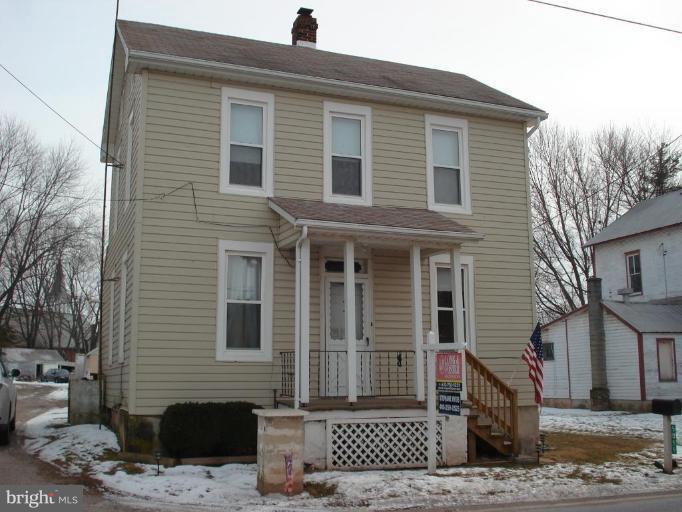 a front view of a house with a tree