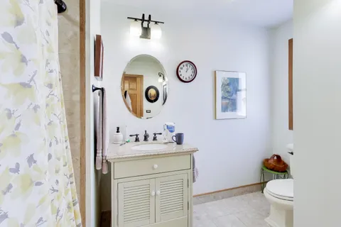 a bathroom with a sink mirror and toilet