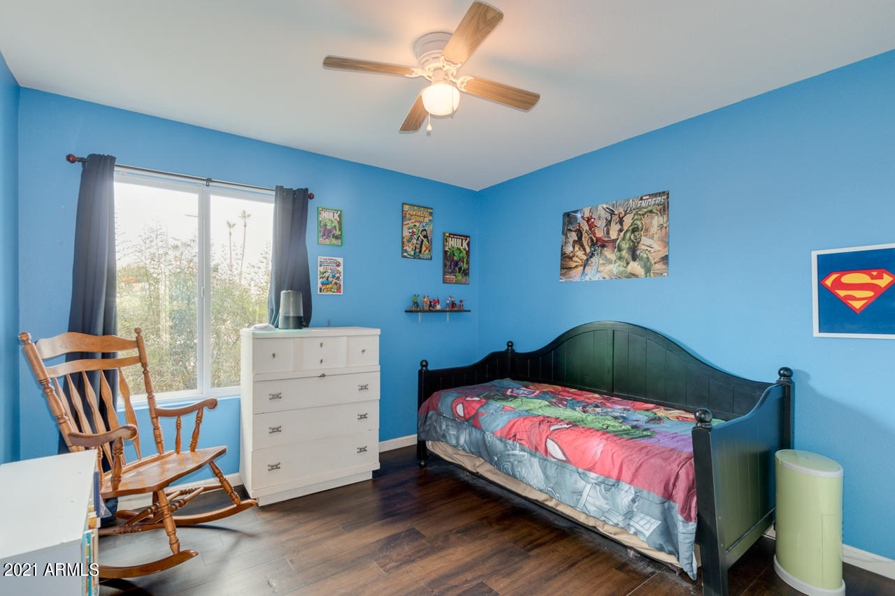 4215 West Dailey Street Phoenix, AZ 85053 - Photo 21 of 32 a bedroom with a bed and a chandelier