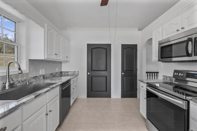 a kitchen with stainless steel appliances granite countertop a refrigerator stove and sink