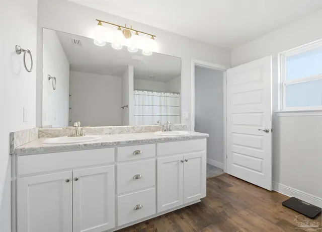 a bathroom with a granite countertop sink double and mirror