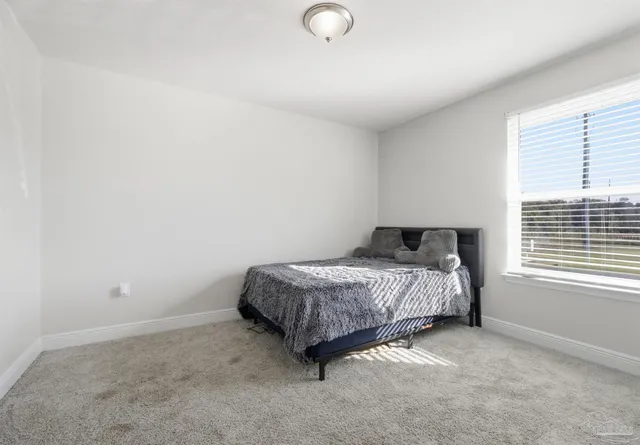 a spacious bedroom with a bed and a window