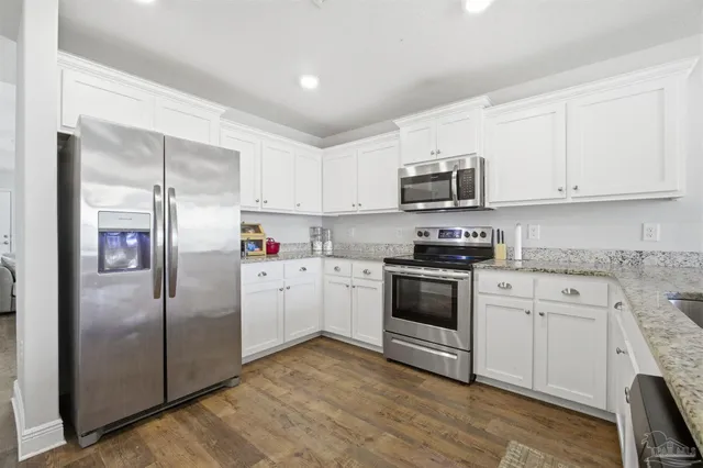 a kitchen with cabinets stainless steel appliances and a counter space
