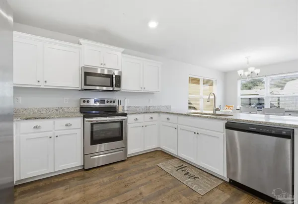 a kitchen with granite countertop white cabinets and white appliances