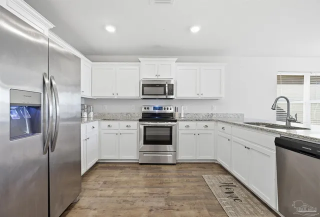 a kitchen with cabinets stainless steel appliances and a counter space