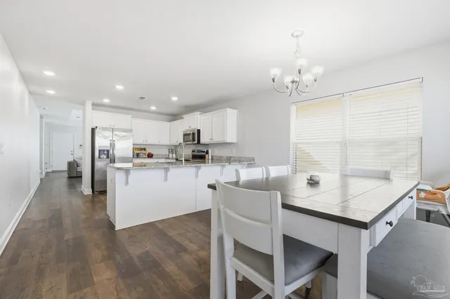 a kitchen with kitchen island a white counter top space cabinets and stainless steel appliances