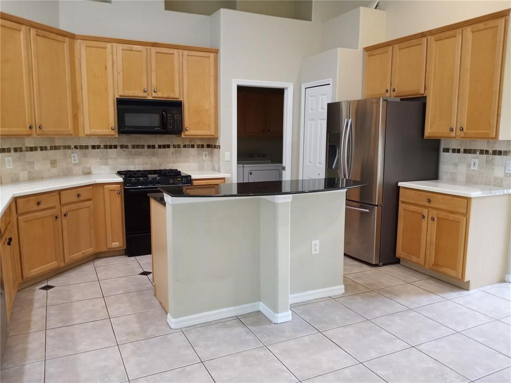 6506 Waters Edge Way Lakewood Ranch, FL 34202 - Photo 5 of 14 a kitchen with stainless steel appliances a refrigerator sink and microwave