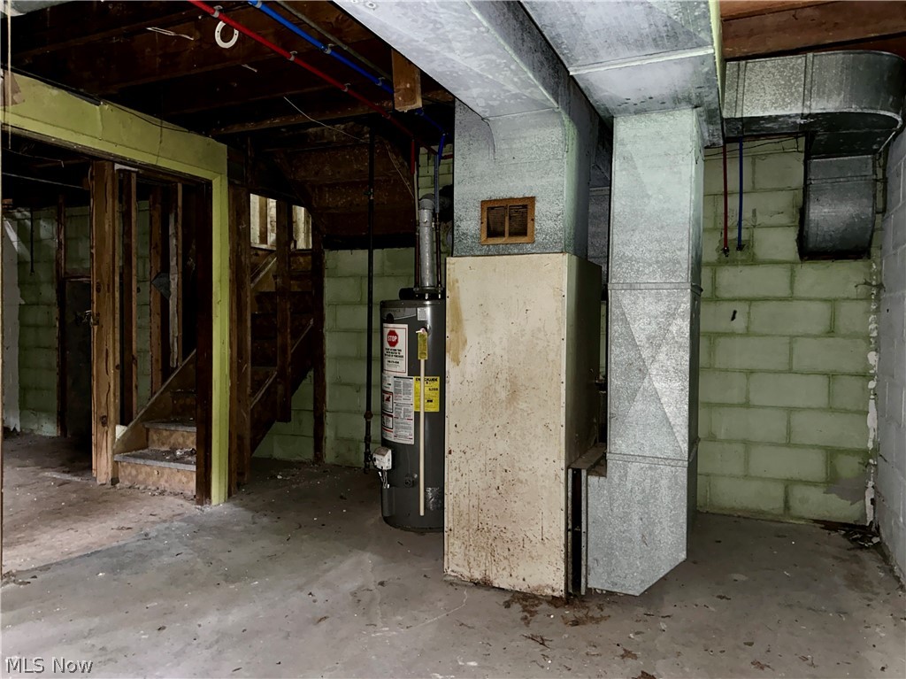 5319 Fairtree Road Bedford Heights, OH 44146 - Photo 20 of 27 Unfinished basement space featuring exposed wooden ceiling joists, concrete block walls, and a visible water heater