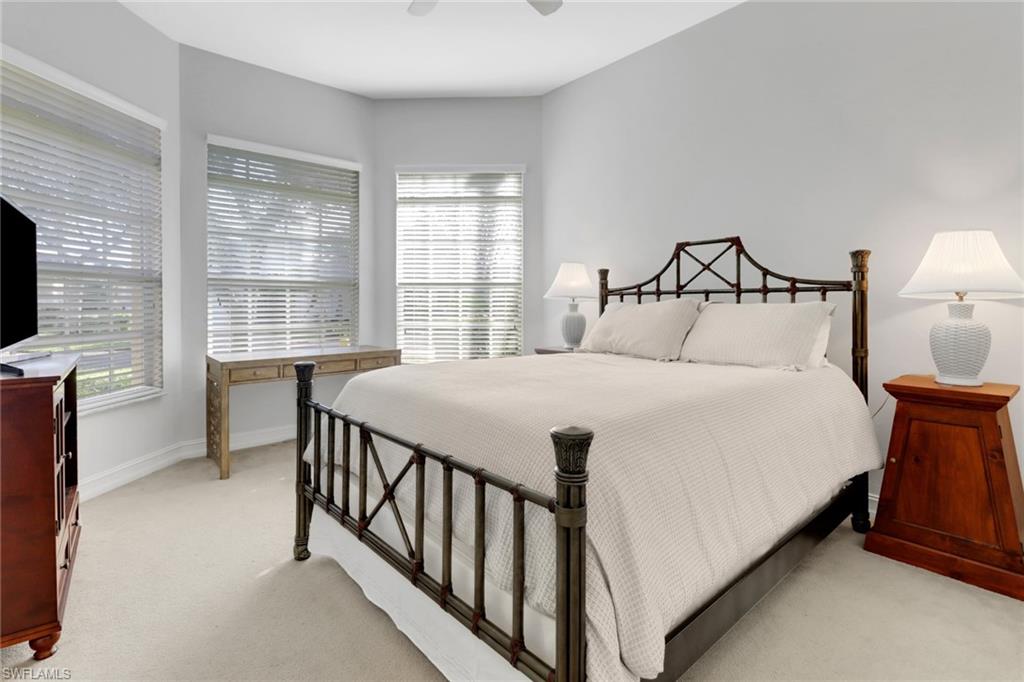 6757 Bent Grass Drive Naples, FL 34113 - Photo 16 of 27 a bedroom with a bed and a flat tv screen on dresser