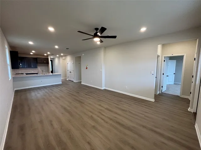 wooden floor in an empty room with a kitchen