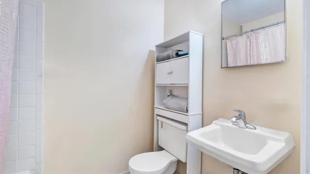 a bathroom with a sink toilet and mirror