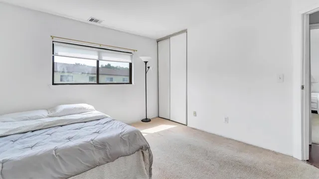 a bedroom with a bed and a window