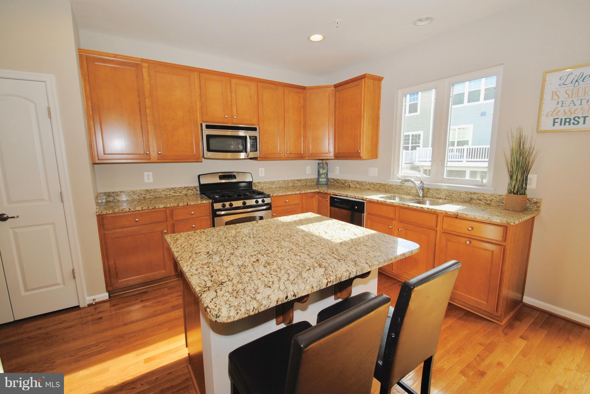2707 Amber Crest Road Hanover, MD 21076 - Photo 3 of 30 a kitchen with a sink a stove a kitchen island and chairs