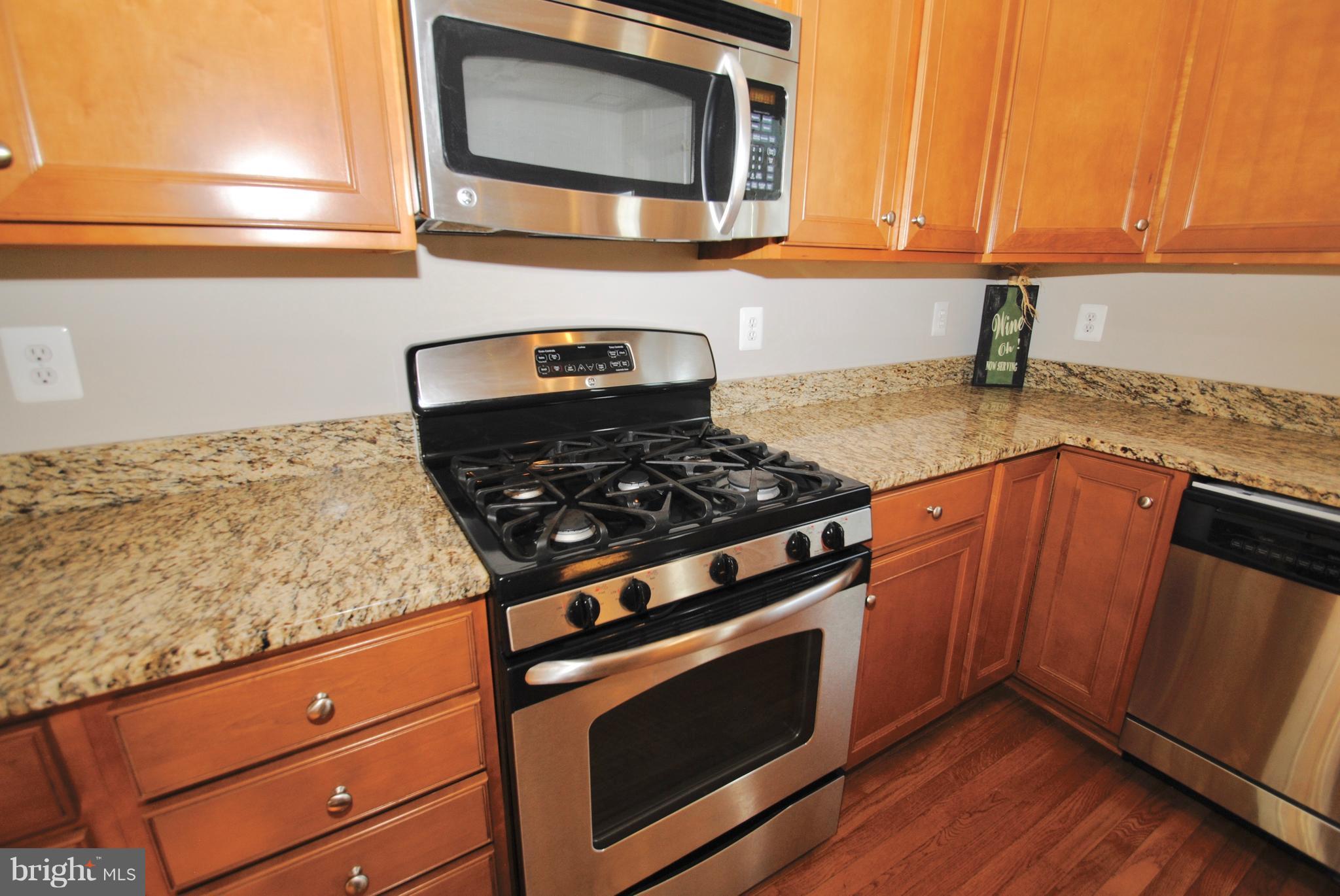 2707 Amber Crest Road Hanover, MD 21076 - Photo 5 of 30 a kitchen with granite countertop stainless steel appliances a stove a microwave and sink