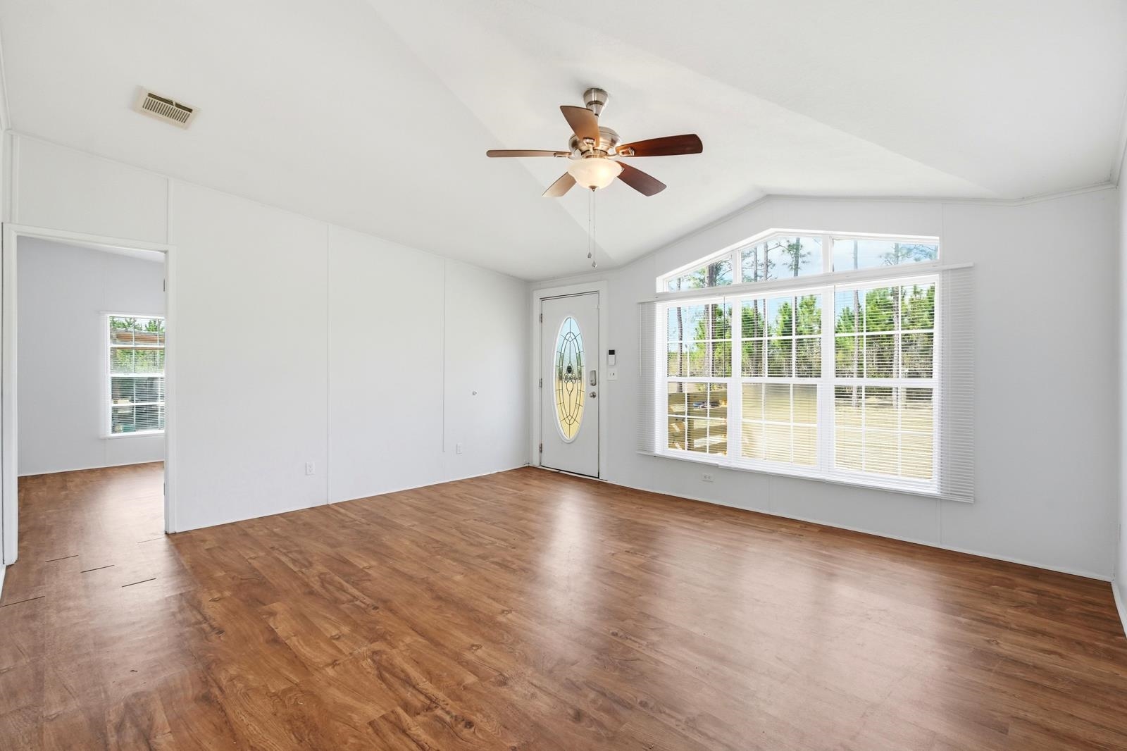 299 Cayenne Street Interlachen, FL 32148 - Photo 12 of 73 Unfurnished living room with a ceiling fan, dark wood-style flooring, and vaulted ceiling