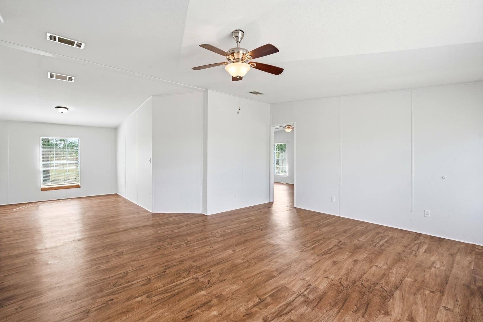 299 Cayenne Street Interlachen, FL 32148 - Photo 13 of 73 Empty room with dark wood-type flooring and a ceiling fan