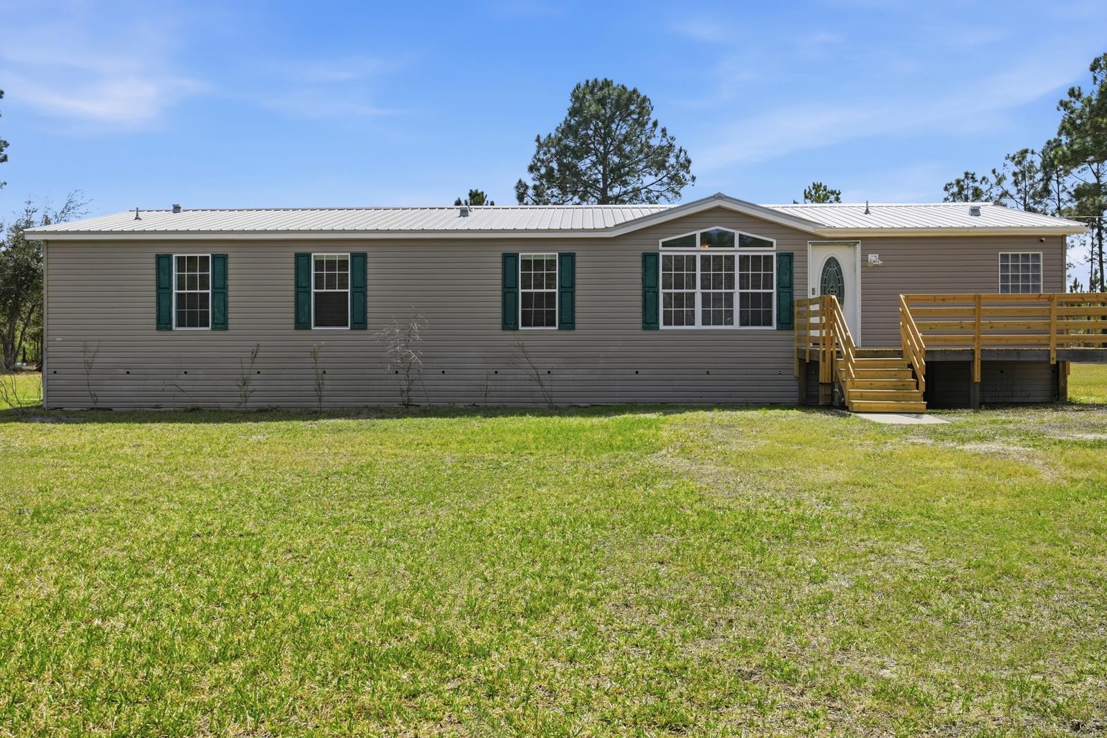 299 Cayenne Street Interlachen, FL 32148 - Photo 2 of 73 Back of property featuring a yard and a metal roof