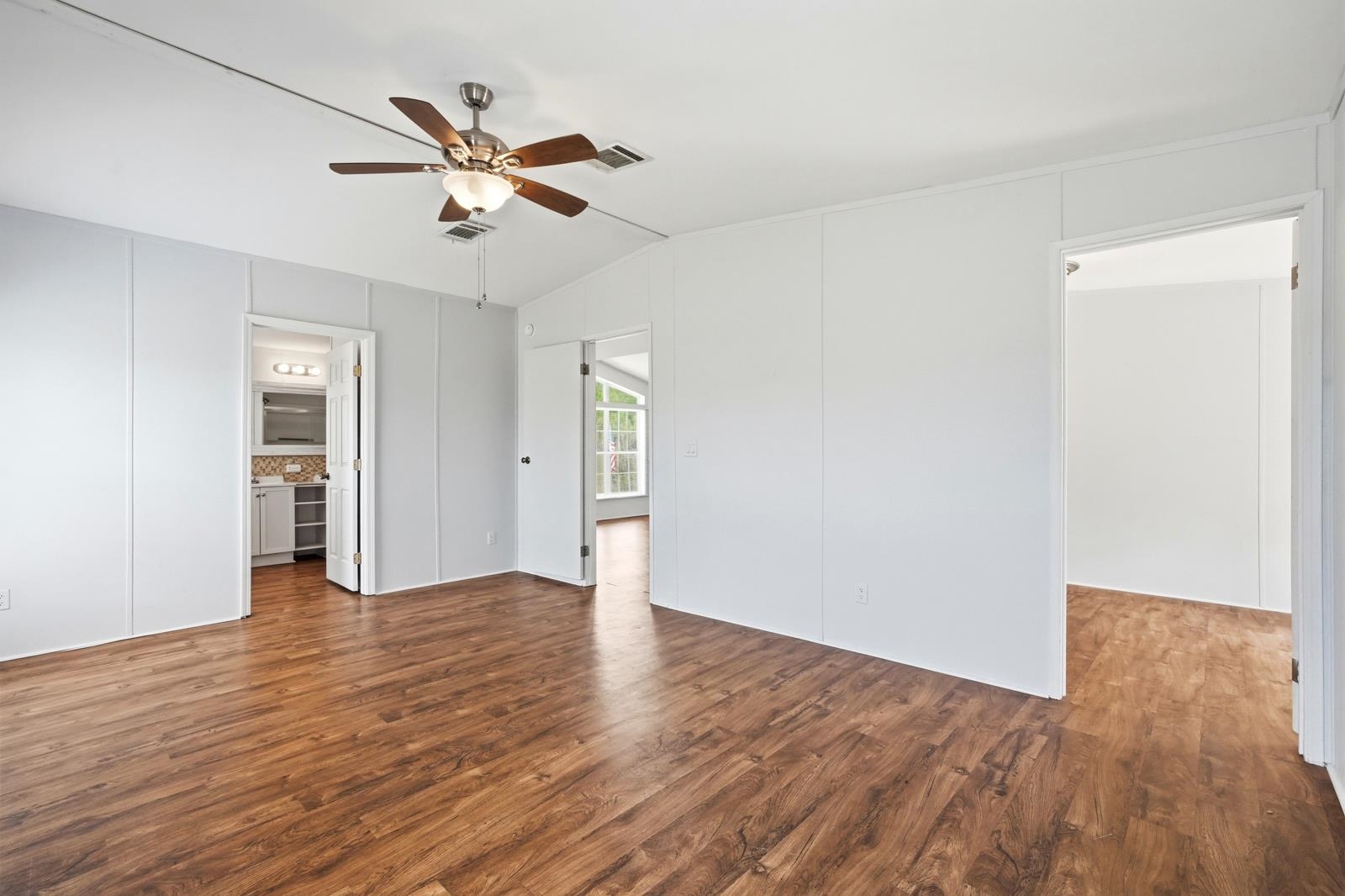 299 Cayenne Street Interlachen, FL 32148 - Photo 24 of 73 Unfurnished bedroom with dark wood finished floors, lofted ceiling, a ceiling fan, and ensuite bath