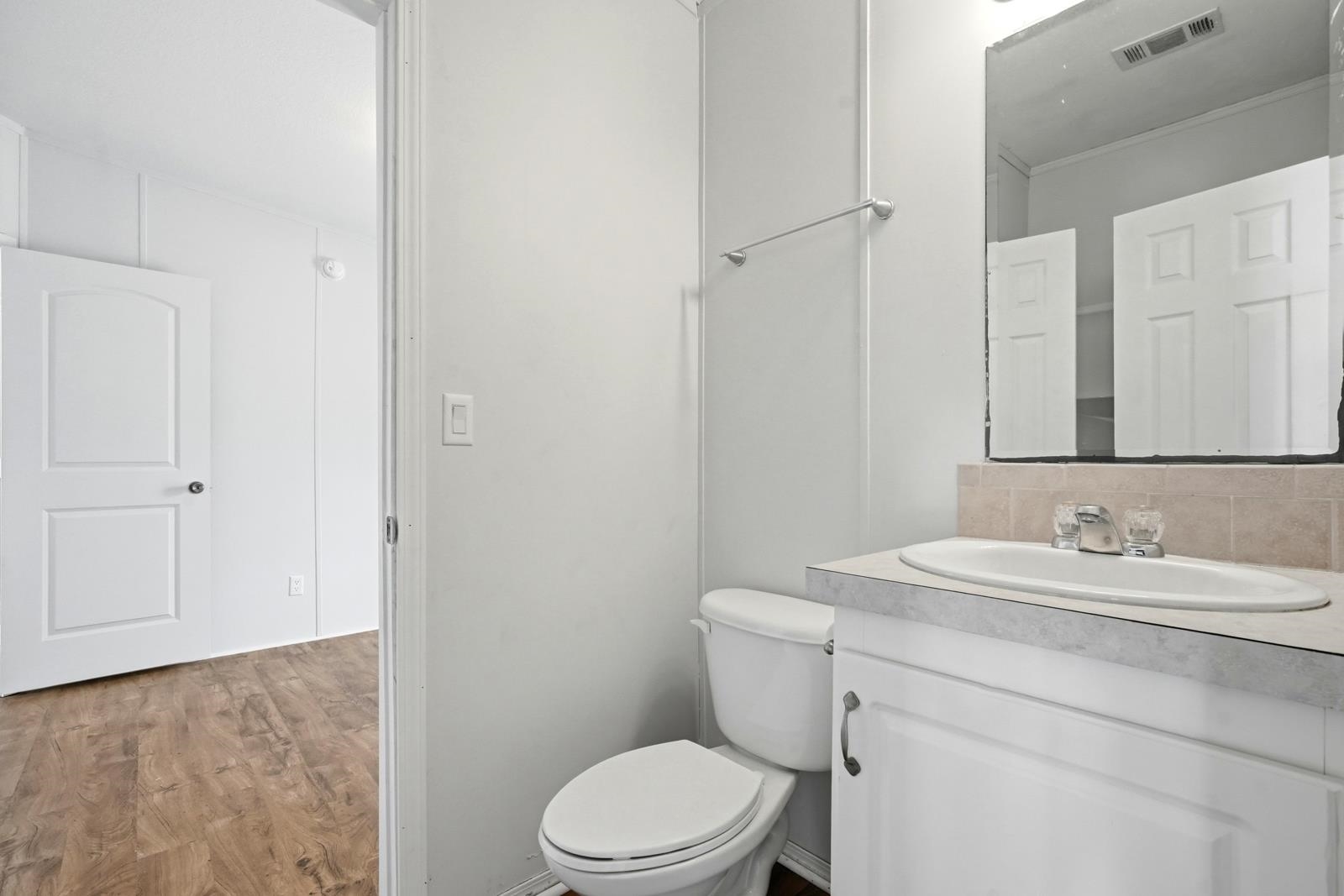 299 Cayenne Street Interlachen, FL 32148 - Photo 32 of 73 Half bath featuring light wood finished floors, vanity, crown molding, and decorative backsplash