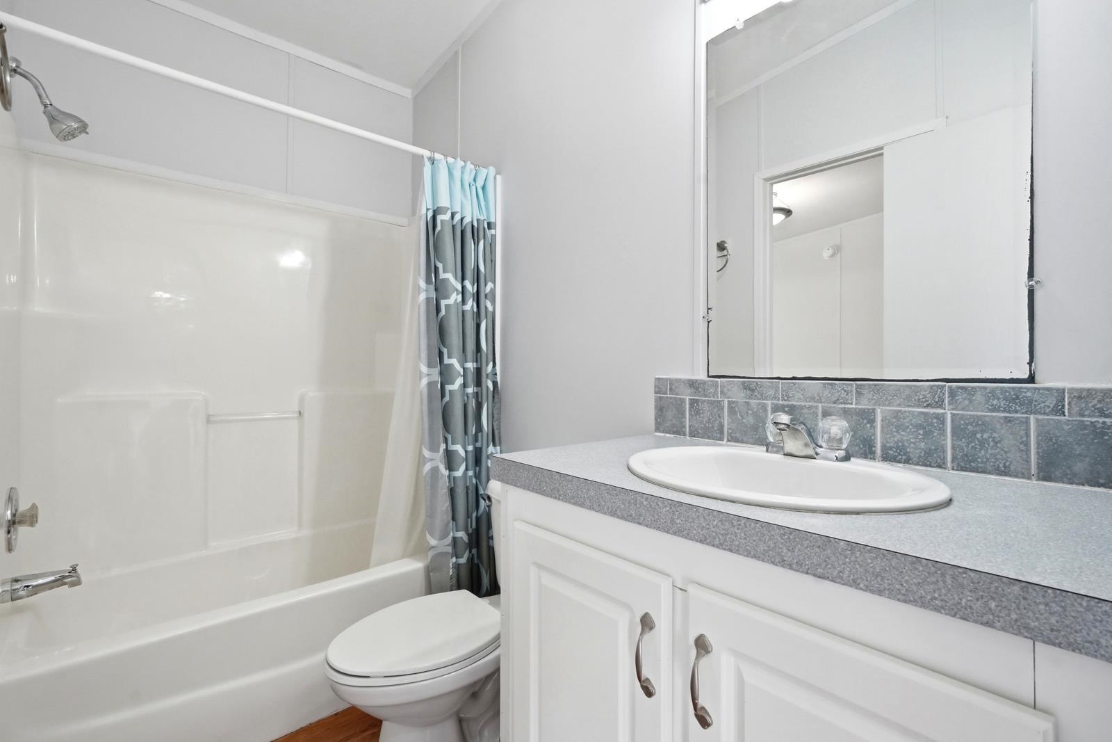 299 Cayenne Street Interlachen, FL 32148 - Photo 36 of 73 Bathroom featuring vanity, shower / bath combination with curtain, and backsplash