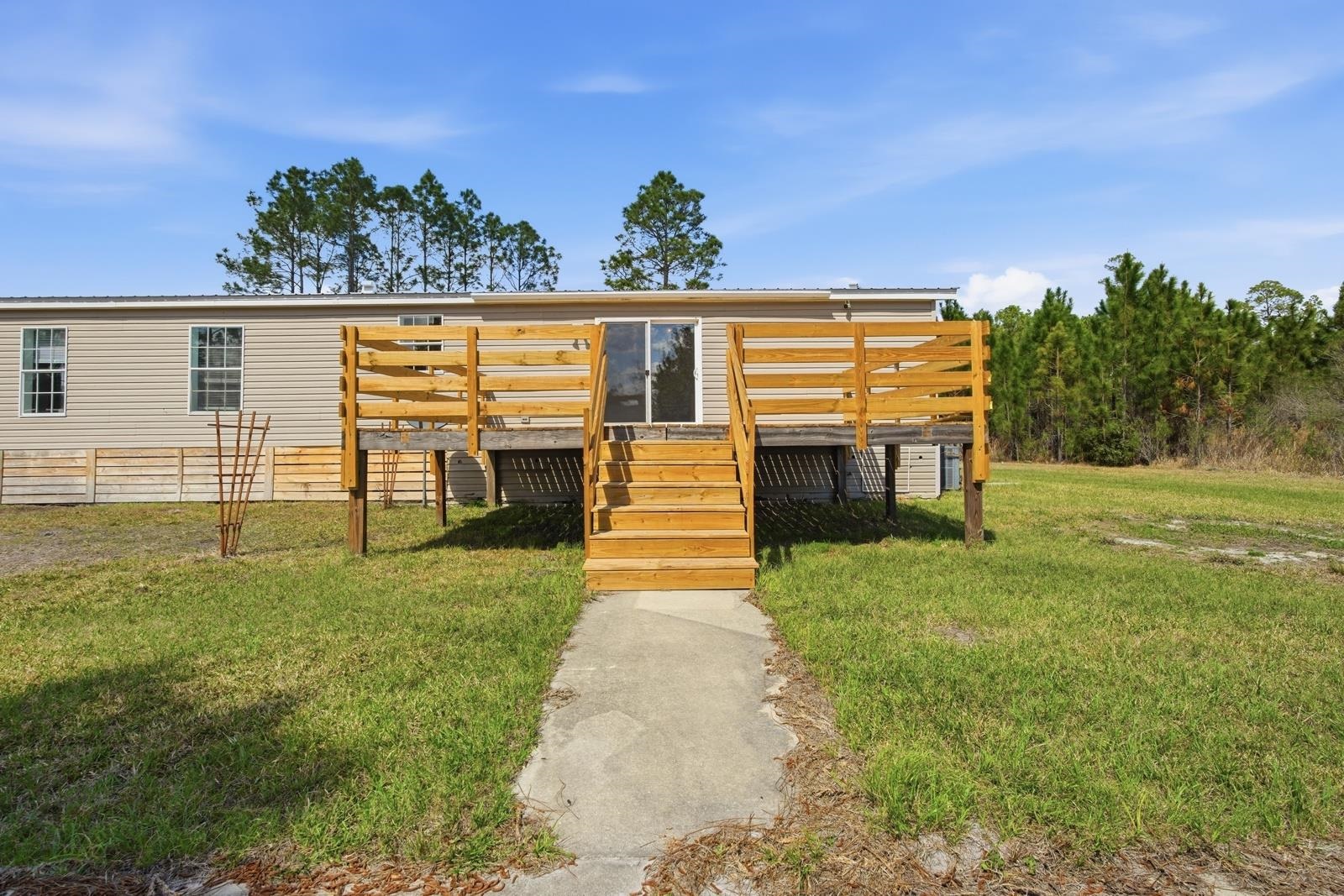299 Cayenne Street Interlachen, FL 32148 - Photo 41 of 73 View of front of property featuring a front yard, a metal roof, and a deck