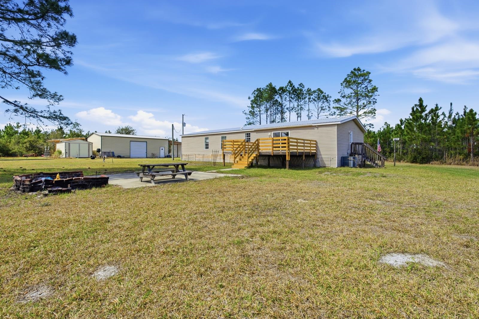 299 Cayenne Street Interlachen, FL 32148 - Photo 47 of 73 Rear view of house featuring a fire pit, a patio, an outdoor structure, and a lawn