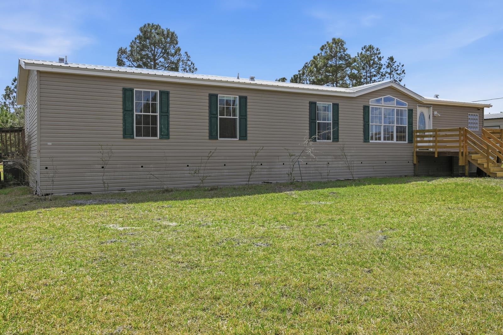 299 Cayenne Street Interlachen, FL 32148 - Photo 5 of 73 View of side of home featuring a yard and a metal roof