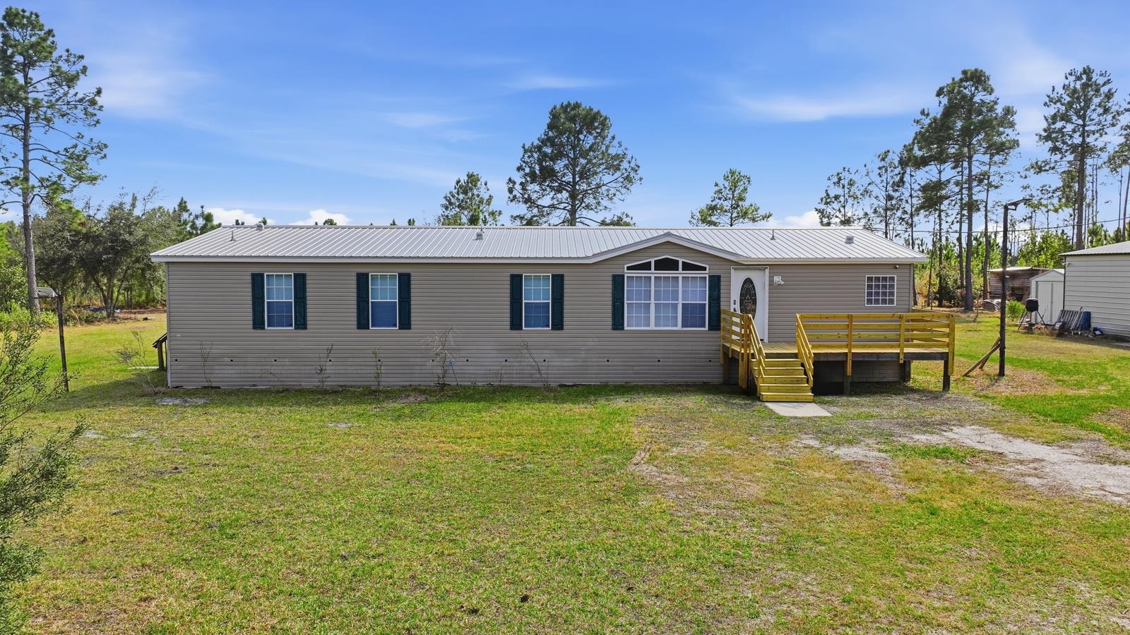 299 Cayenne Street Interlachen, FL 32148 - Photo 62 of 73 Manufactured / mobile home with a metal roof, a front lawn, and a deck