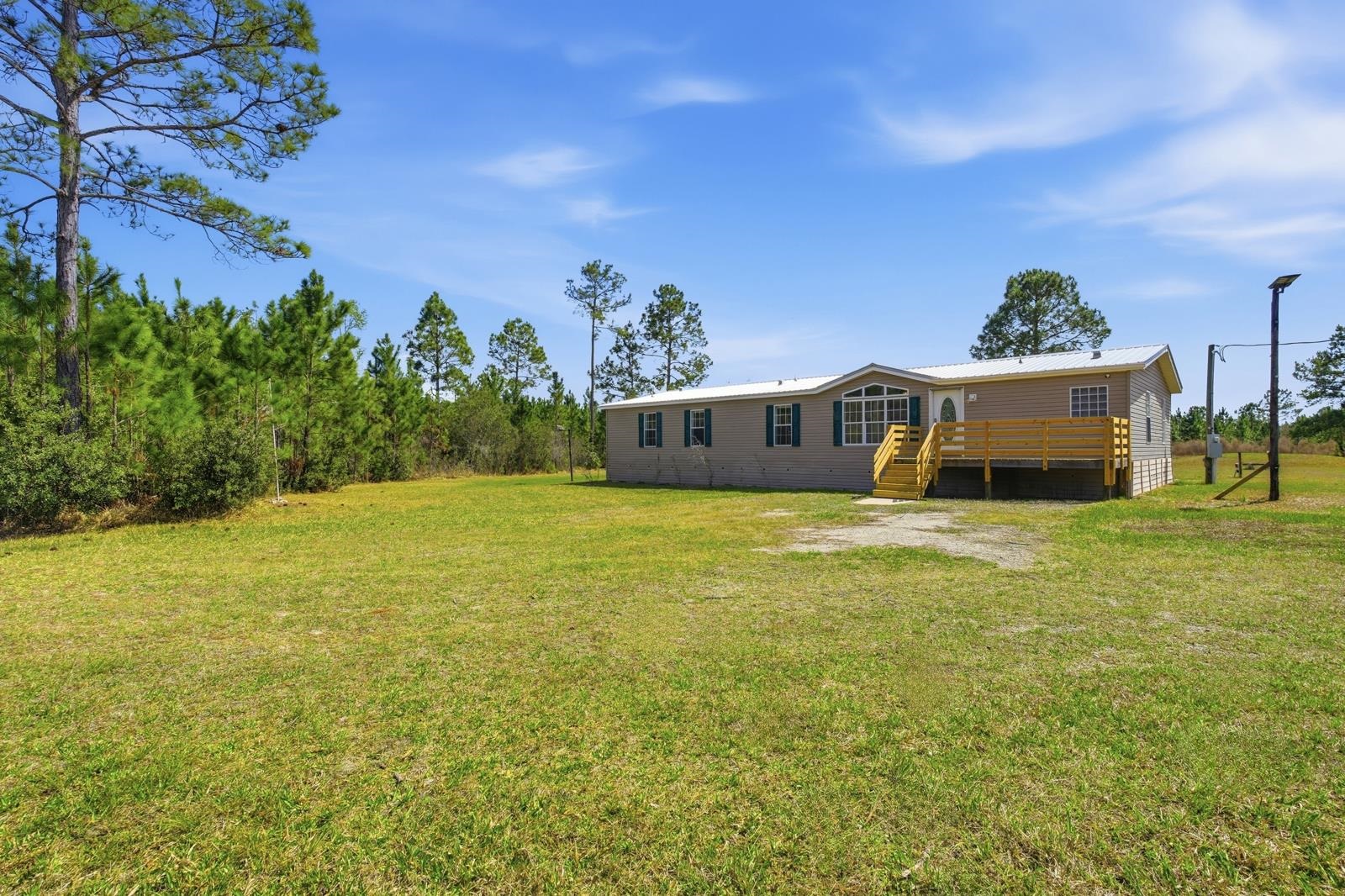 299 Cayenne Street Interlachen, FL 32148 - Photo 8 of 73 Rear view of house featuring a yard, a metal roof, and a wooden deck