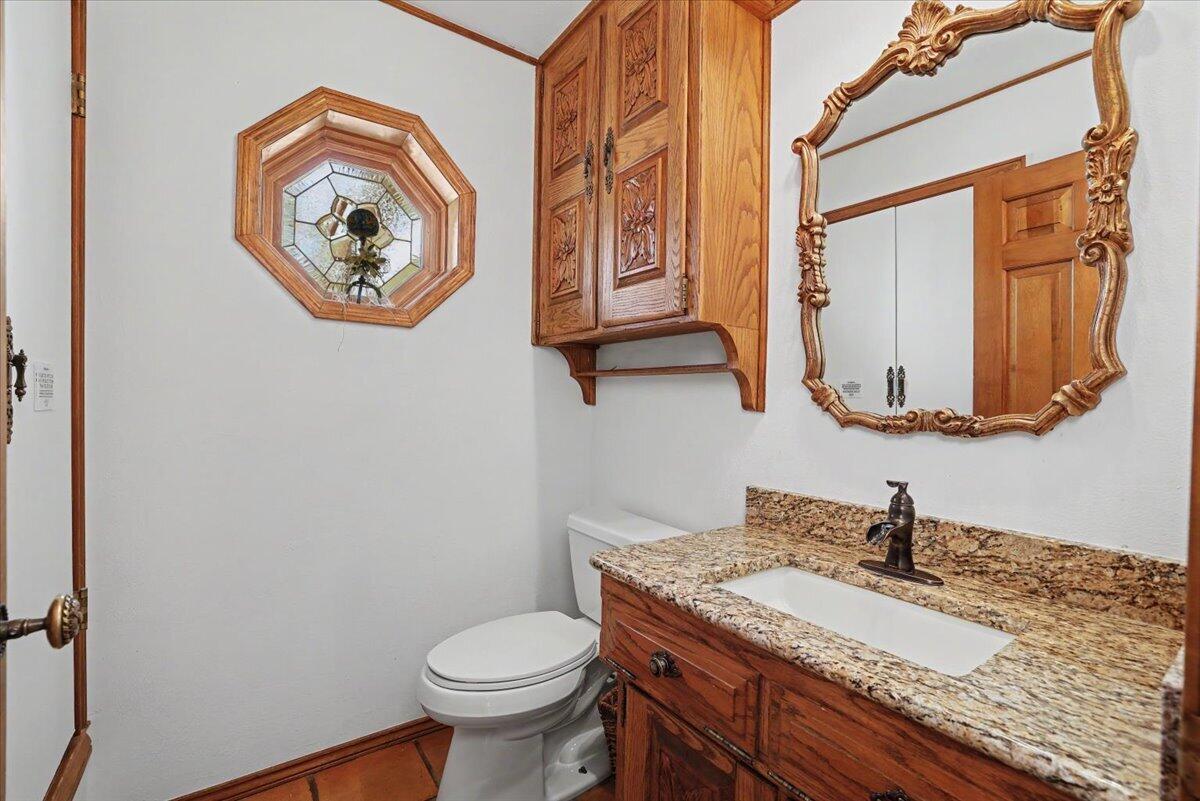 5 West Lakeshore Drive Ransom Canyon, TX 79366 - Photo 26 of 61 a bathroom with a granite countertop toilet sink and mirror