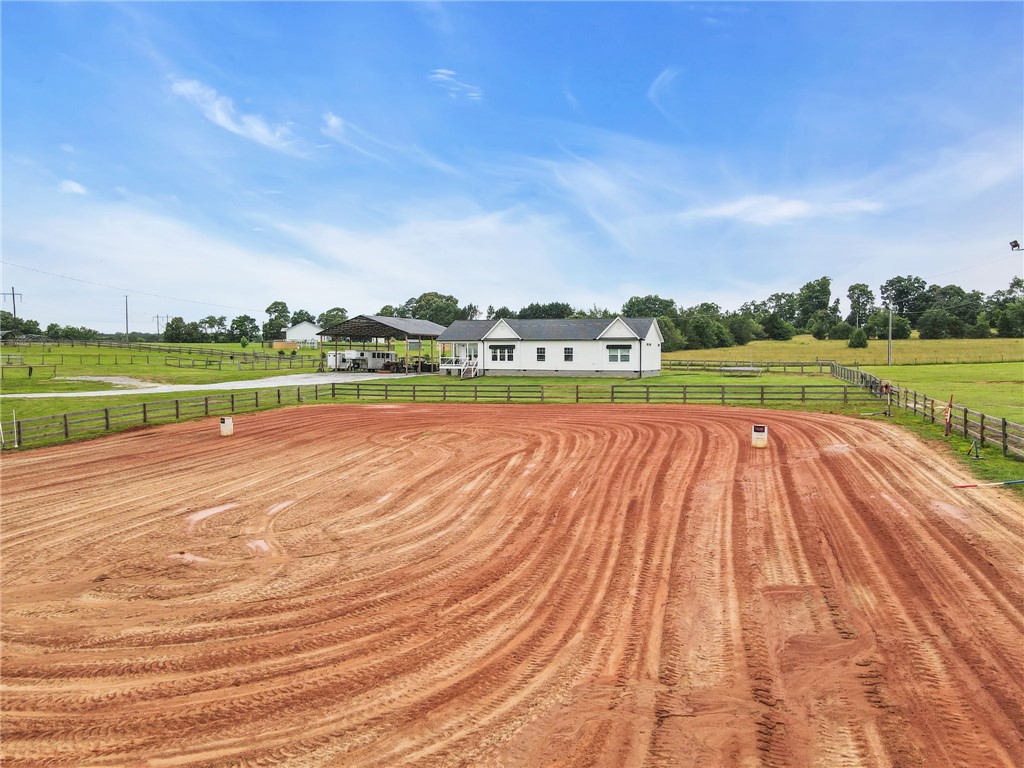 615 Wilson Road Central, SC 29630 - Photo 34 of 50 An expansive outdoor riding arena rests under open skies adjacent to the main residence.