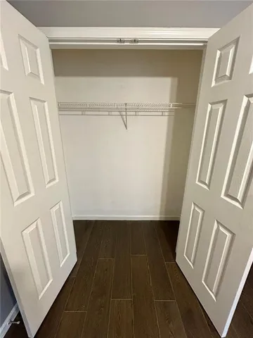 a view of walk in closet with wooden floor