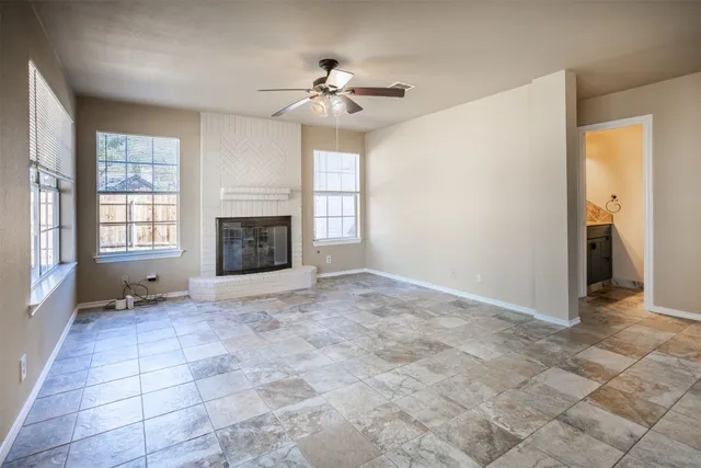 a view of an empty room with a fireplace and a window