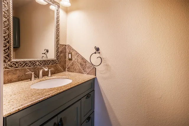 a bathroom with a granite countertop sink and a mirror