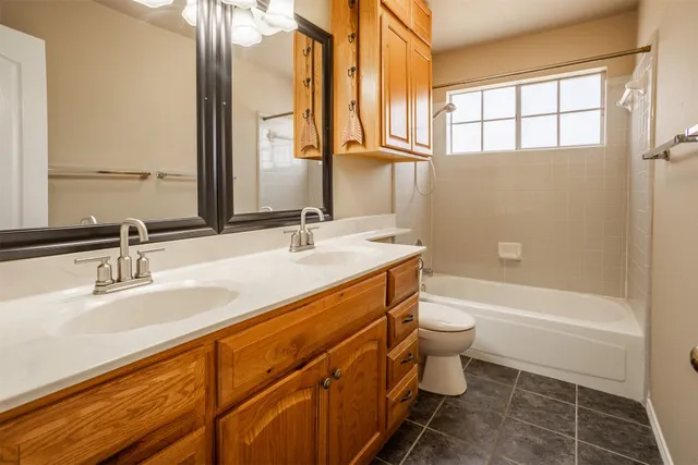 a bathroom with a double vanity sink toilet and shower