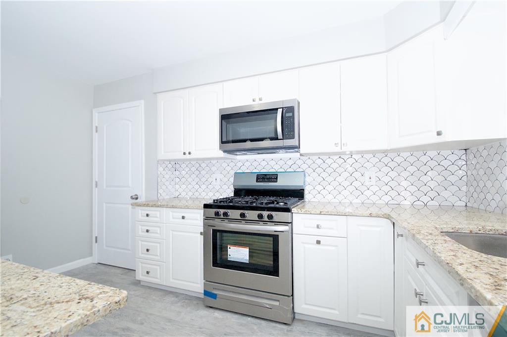 9 Brookside Road Edison, NJ 08817 - Photo 11 of 24 a kitchen with granite countertop white cabinets and stainless steel appliances