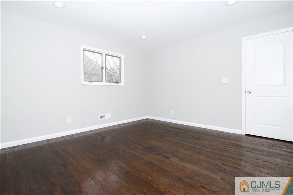 9 Brookside Road Edison, NJ 08817 - Photo 13 of 24 an empty room with wooden floor and windows