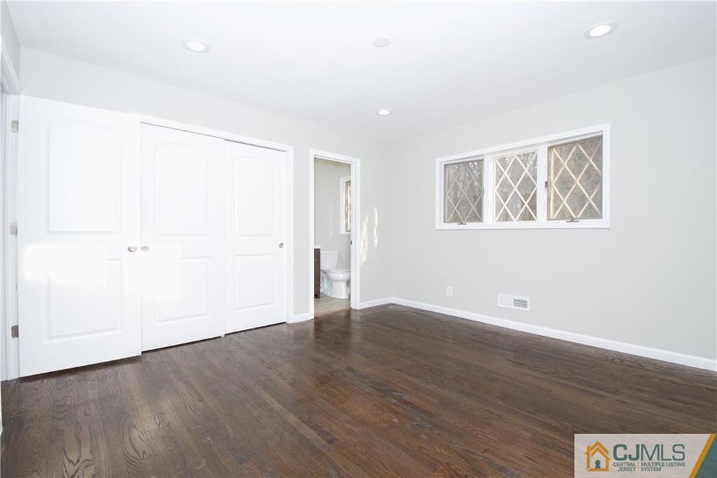9 Brookside Road Edison, NJ 08817 - Photo 14 of 24 an empty room with wooden floor and windows