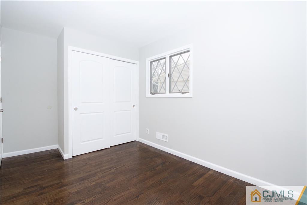 9 Brookside Road Edison, NJ 08817 - Photo 20 of 24 an empty room with wooden floor and windows
