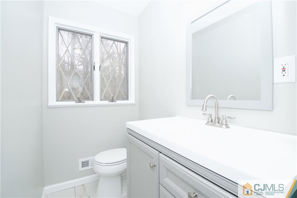 9 Brookside Road Edison, NJ 08817 - Photo 23 of 24 a bathroom with a sink a toilet and a mirror