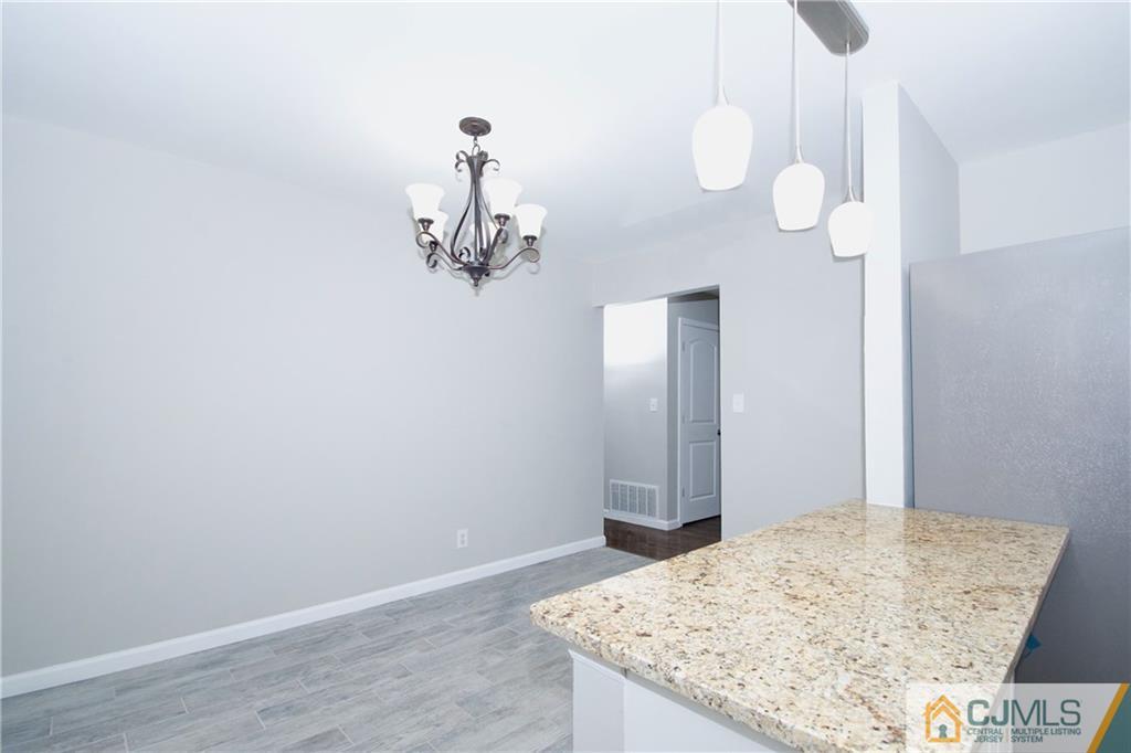 9 Brookside Road Edison, NJ 08817 - Photo 10 of 24 a view of a hallway with wooden floor and chandelier