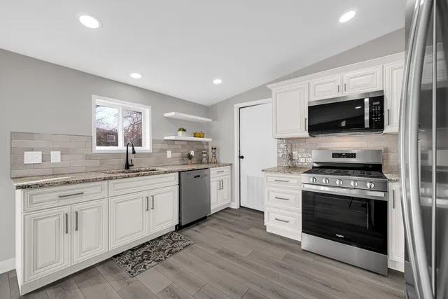 a kitchen with granite countertop a stove top oven sink and cabinets
