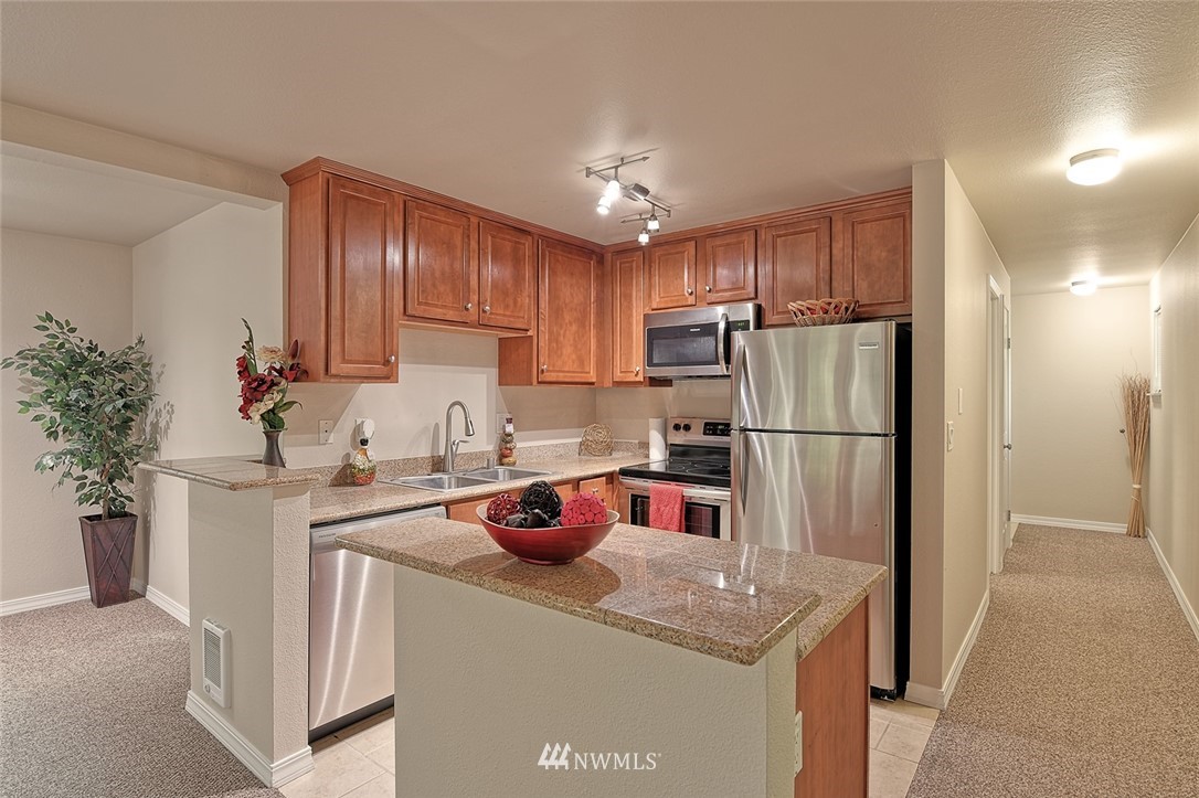 20330 Bothell Everett Highway, Unit C204 Bothell, WA 98012 - Photo 2 of 24 a kitchen with a refrigerator a stove a sink and cabinets