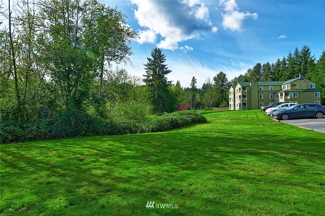20330 Bothell Everett Highway, Unit C204 Bothell, WA 98012 - Photo 15 of 24 a view of a grassy field with trees in the background