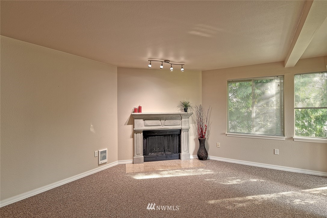 20330 Bothell Everett Highway, Unit C204 Bothell, WA 98012 - Photo 4 of 24 an empty room with fireplace and windows