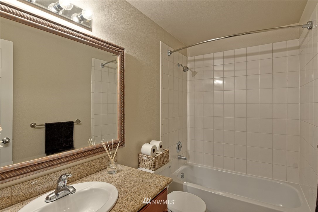 20330 Bothell Everett Highway, Unit C204 Bothell, WA 98012 - Photo 10 of 24 a bathroom with a granite countertop bathtub shower sink and a mirror